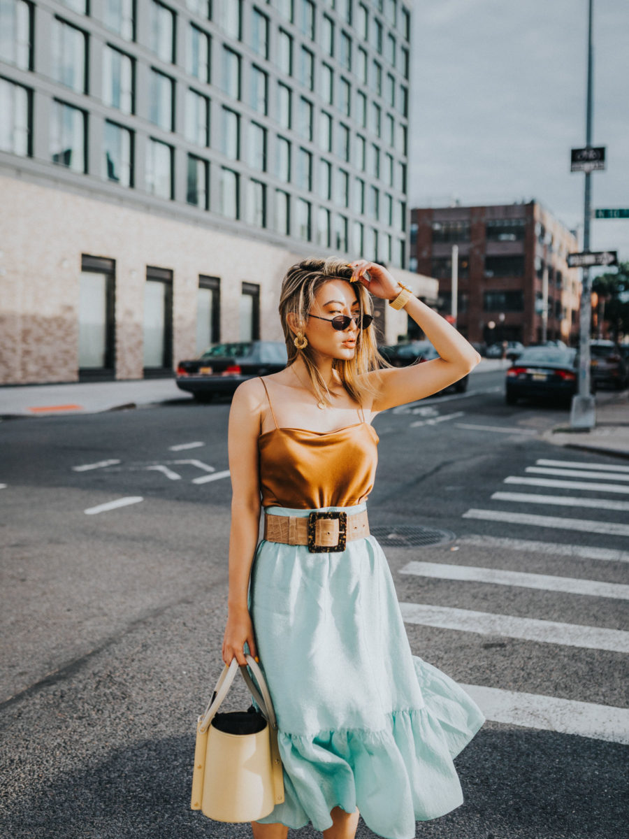 jessica wang wearing a brown silk tank top and a light blue slip skirt with a croc embossed leather belt while sharing products to get a summer glow // Jessica Wang - Notjessfashion.com