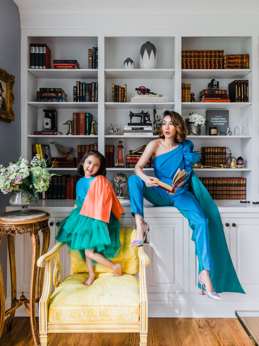 jessica wang wearing a blue jumpsuit with her daughter in front of a bookcase // jessica wang - Notjessfashion.com