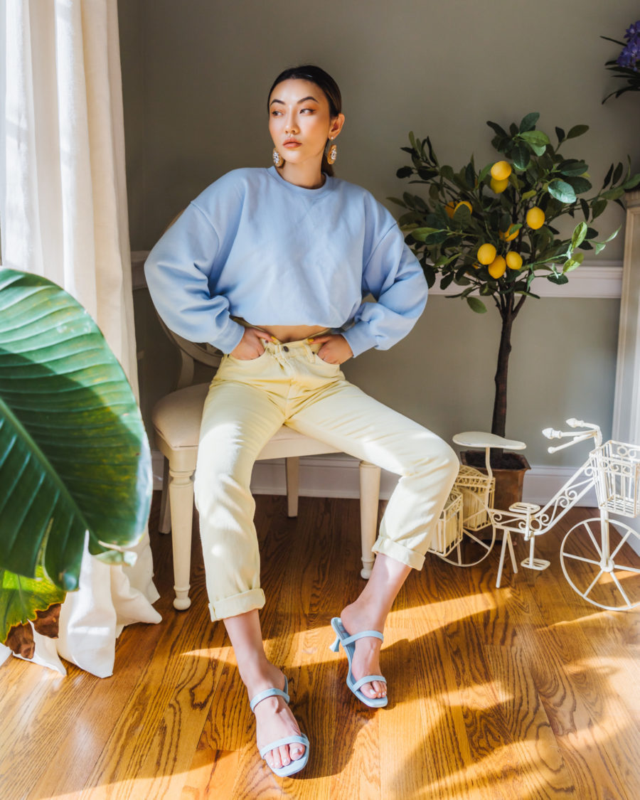jessica wang wearing a light blue sweater, pale yellow denim jeans, and blue slides while sharing her favorite end of summer outfits // Jessica Wang - Notjessfashion.com
