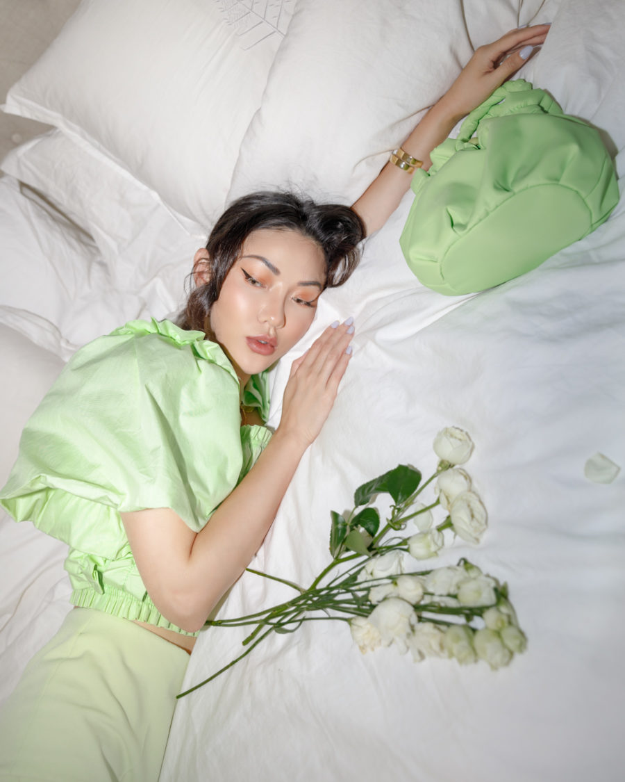 jessica wang wearing green outfit on bed with roses sharing nordstrom anniversary sale home finds // Jessica Wang - Notjessfashion.com